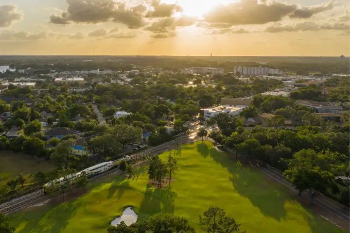 Aerial image of SunRail Train traveling through a golf course in Winter Park, FL.