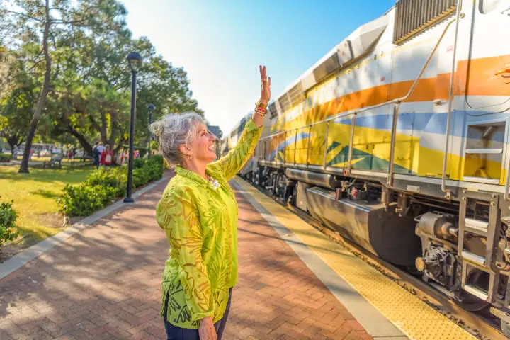 Onlooker waves to a SunRail engineer as they operate the train through the SunRail Winter Park / Amtrak Station.