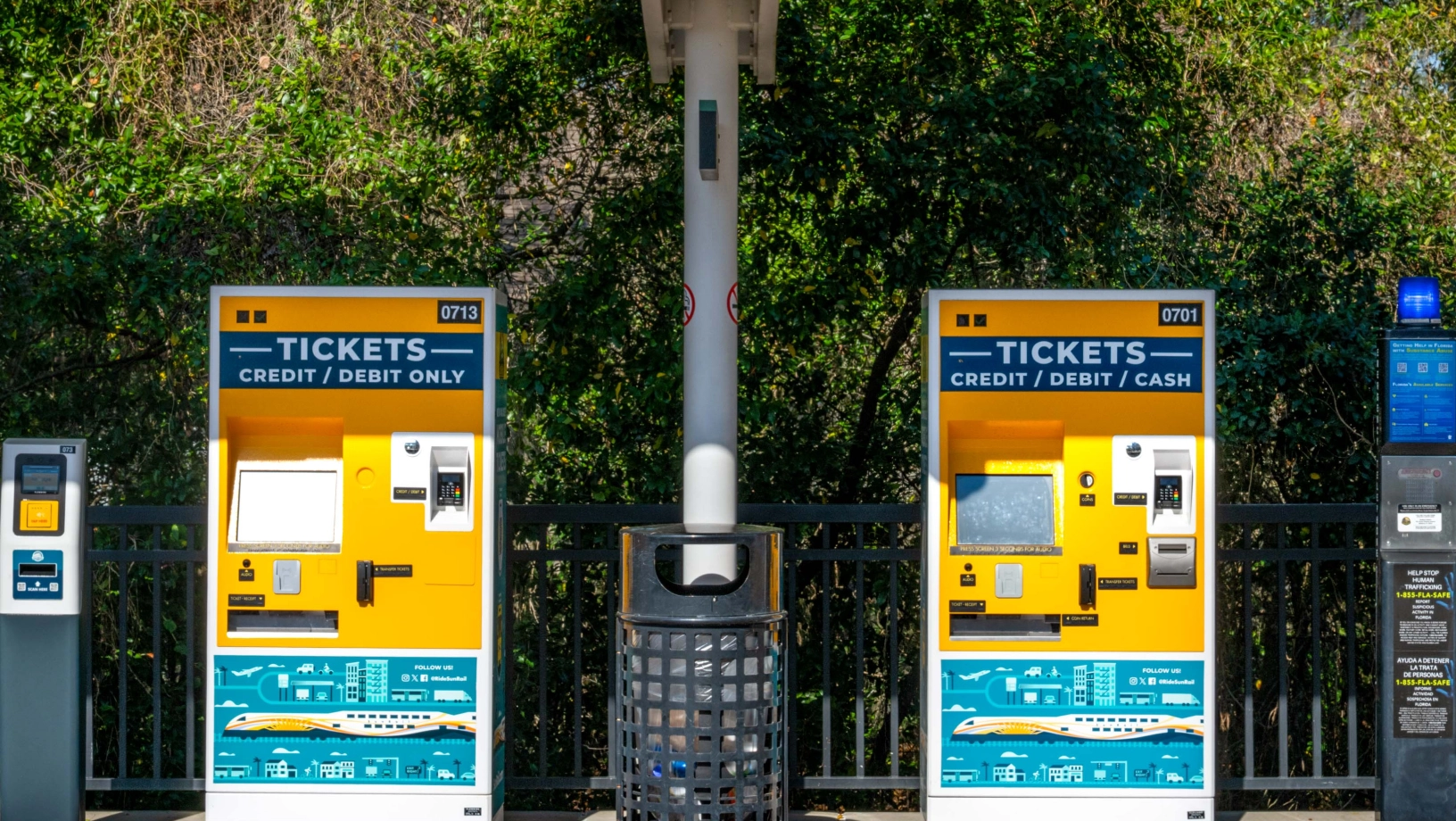 A ticket validator unit, two ticket vending machines, and an emergency call box at a SunRail station.