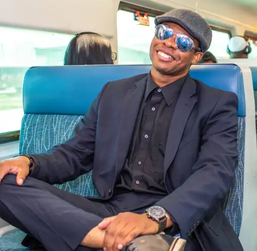 Man relaxing on SunRail train, wearing sunglasses.