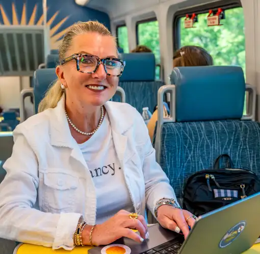 Female passenger on SunRail working on laptop.